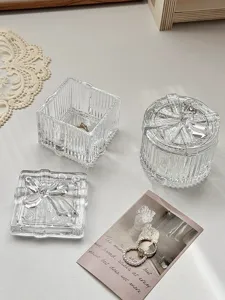 Nahaufnahme der transparenten Glasaufbewahrungsbox mit niedlichem Schleifendeckel für Schmuck.