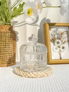 Vue détaillée d'un bocal à bonbons en verre transparent avec couvercle couronne, déco table.
