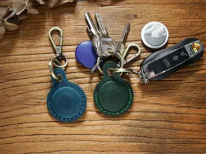 Leather protective case detail showing premium texture and sturdy metal keychain for AirTag.