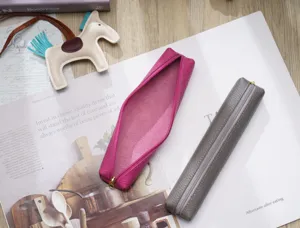 Primo piano dettagliato di astucci minimalisti in pelle rosa e grigia con consistenza.