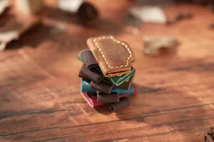 Close-up stack of colorful genuine leather magnetic pen clips and vintage bookmark loops.