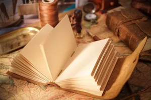 Dettaglio di un taccuino in pelle vintage, pagine in carta kraft vuota, decoro retrò.