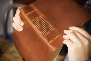 Quaderno in vera pelle fatto a mano con cuciture rustiche visibili per appunti quotidiani.