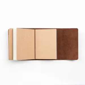 Detailaufnahme eines braunen Vintage-Leder-Reisetagebuchs mit Kraftpapier-Einlagen und Bändern.