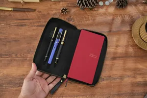 Leder Reißverschluss Planertasche mit rotem Notizbuch und Stiften, hochwertiger Organizer.