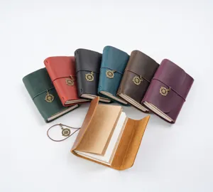 Detailansicht von Vintage-Echtleder-Reisetagebüchern in mehreren bunten Farben mit Kompass-Anhängern.
