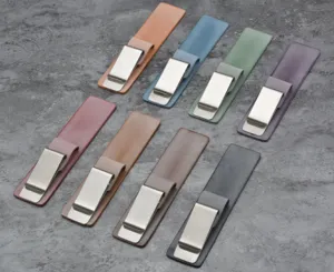 Primo piano di clip portapenne in vera pelle multicolore con clip metalliche per quaderni.