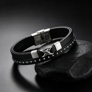Close-up van de meerlaagse lederen titanium stalen armband met oneindigheidssymbool.