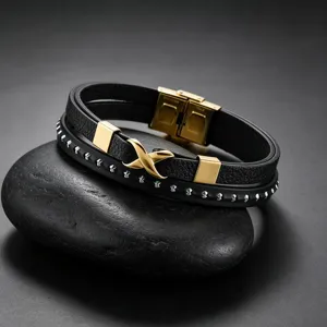 Gedetailleerd overzicht van de geweven leren herenarmband met gouden X-sluiting en metalen studs.