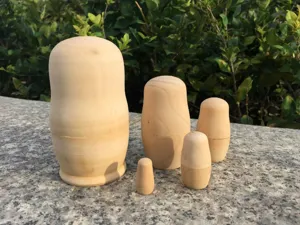 Muñecas rusas de madera sin terminar en blanco para pintura DIY vista de detalle.