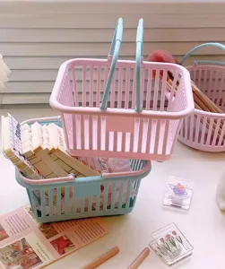 Cute plastic desktop storage basket with handle, pastel pink and blue organizer bin.