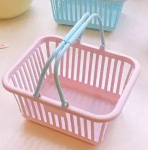 Small plastic desktop storage basket with dual handles, cute pastel pink design for cosmetics.