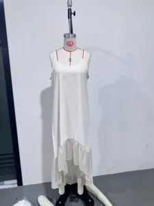 Robe nuisette blanche à bretelles avec ourlet à volant irrégulier, style vacances d'été.