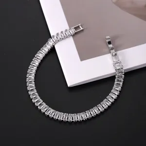 Detailed close-up of a silver tennis bracelet with sparkling rectangular AAA zircons