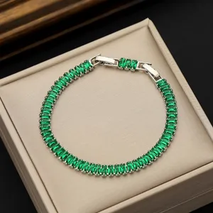 Close-up detail of silver-toned tennis bracelet featuring radiant AAA green zircon stones