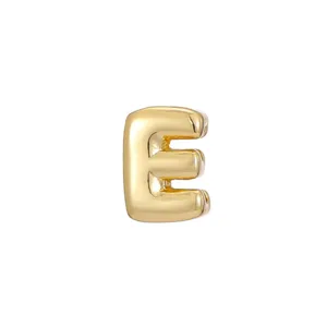 Detailed macro view of a glossy gold bubble letter E charm for DIY jewelry designs
