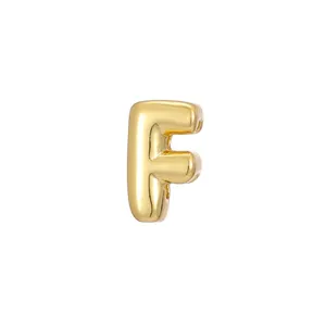 Detailed macro view of a 3D golden bubble-style letter F jewelry charm for DIY craft