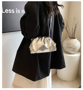 Elegante metallic zilveren geplooide cloud bag gedragen met een zwarte blazer