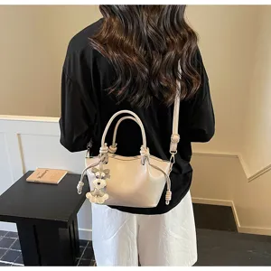 Modische beige Schulter-Eimertasche mit Hundeanhänger in einer Lifestyle-Umgebung