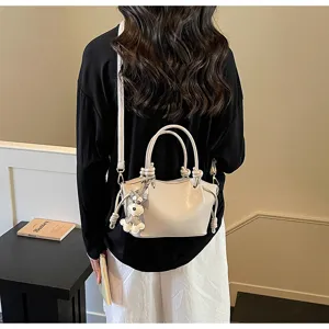 Detailansicht einer beigen minimalistischen Nischen-Eimertasche mit Hundeanhänger