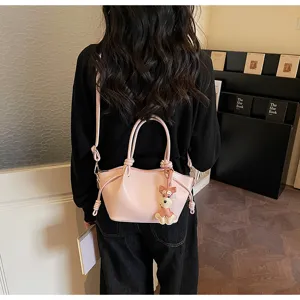 Detailansicht einer rosa Pendler-Beuteltasche mit Hundeanhänger an der Schulter des Models