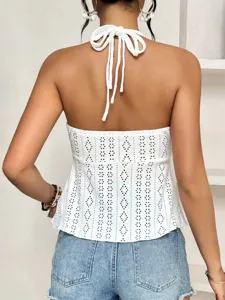 Back view detail of white halter eyelet crop top showing tie straps and cutout design.