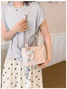 Detailansicht der rosa gepunkteten Beuteltasche mit süßer Spitzenschleife und Anhänger