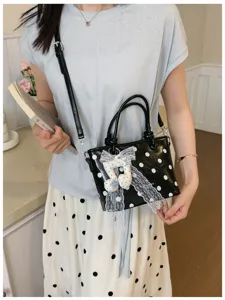 Charmante Polka-Dot-Beuteltasche mit eleganter Spitzenschleife und Notenanhänger-Detail