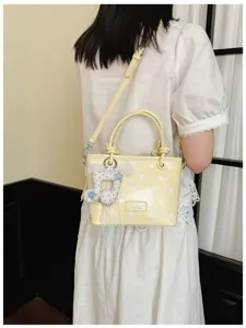Rückansicht eines Models mit gelber Polka-Dot-Handtasche und süßem Musiknoten-Anhänger