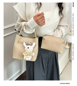 Detailansicht beige Vintage-Eimertasche aus Kieselleder mit Beutel und süßem Hasenanhänger.