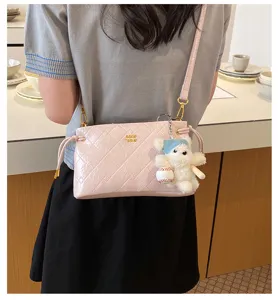 Stylish pink quilted crossbody bag for women featuring a cute plush bear keychain detail