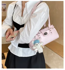 Seitenansicht einer rosa Vintage-Baguette-Tasche mit Schnalle und Bärenanhänger