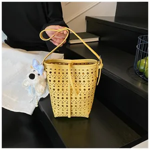 Detailansicht einer gelben lasergeschnittenen Eimertasche mit niedlichem Hundeanhänger
