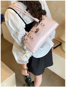 Detailaufnahme einer stilvollen rosa Baguette-Tasche mit silbernem Schloss und Bärenanhänger