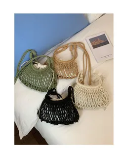 Vue détaillée de sacs seau en filet tissé élégants en quatre couleurs sur un lit blanc
