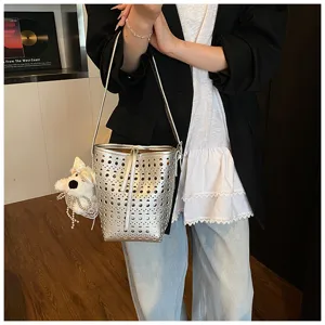 Detailansicht der silbernen gelochten Beuteltasche mit Welpenanhänger am Outfit
