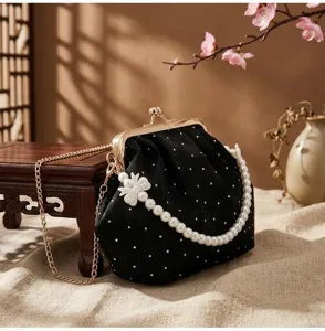 Elegante bolso de noche bordado negro con asa de perlas y cierre de metal dorado detalle vista
