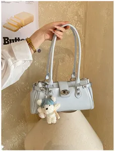 Nahaufnahme einer hellblauen Retro-Baguette-Tasche mit Schloss und Teddybär