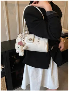 Detaillierte Nahaufnahme einer weißen Vintage-Baguette-Tasche mit modischem Metallschloss.