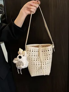 Schicke cremefarbene Eimertasche mit Lochmuster, Trageriemen und süßem Plüsch-Hundeanhänger