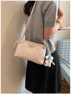 Elegant pink quilted soft leather crossbody bag with a decorative sports bear charm