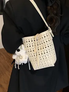 Elegante cremefarbene gelochte Beuteltasche mit Umhängeriemen für die Sommermode.