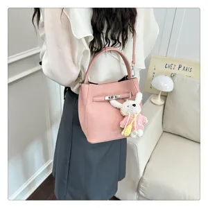 Nahaufnahme der rosa Beuteltasche aus Leder mit Schloss und süßem Hasenanhänger.
