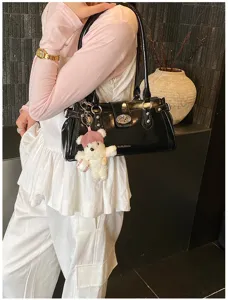 Elegante schwarze Baguette-Schultertasche mit Silberschloss und süßem Bärenanhänger