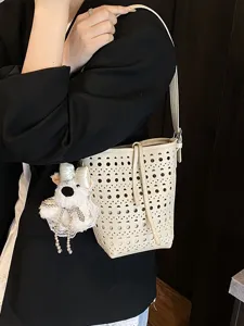 Elegante beige lasergeschnittene Eimertasche für Damen mit süßem Plüschbären-Anhänger