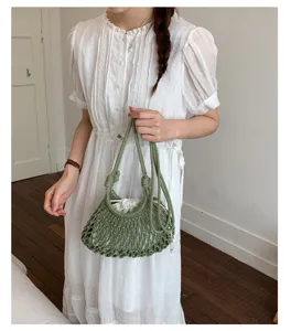 Gros plan d'un sac seau en macramé vert avec une doublure à cordon blanche