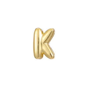 Detailed view of a polished gold-finish puffy bubble letter K charm for necklaces