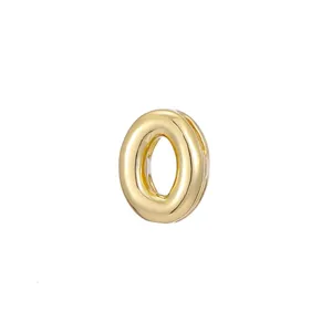 Detail macro view of a shiny gold bubble letter O pendant for DIY jewelry making