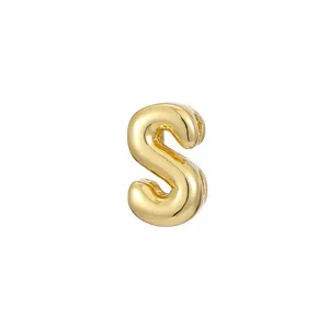 Detail view of glossy golden bubble letter S DIY jewelry pendant charm accessory