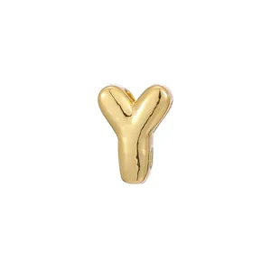 Detailed macro view of a polished gold bubble letter Y charm for DIY necklaces.